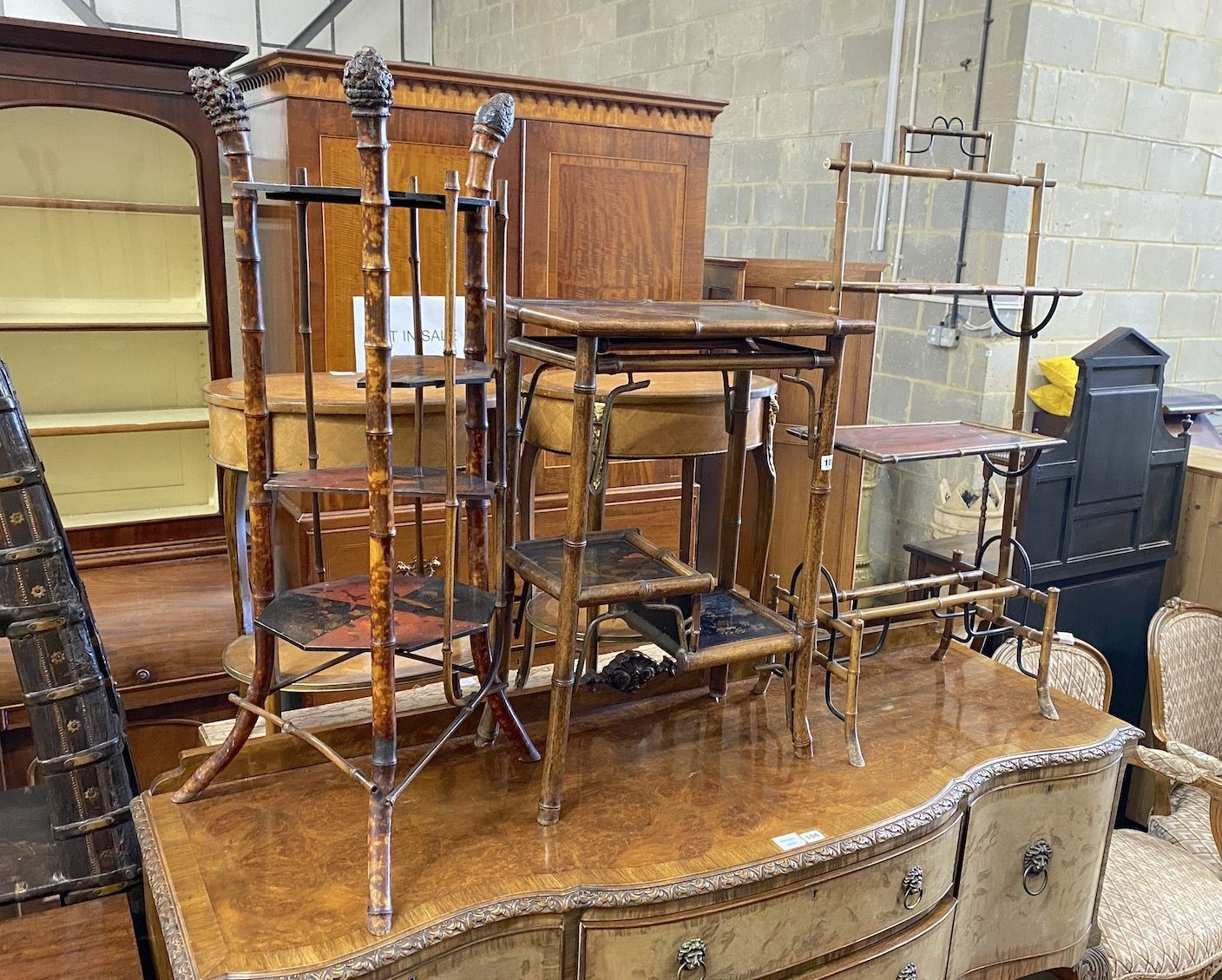 A Victorian three tier lacquer whatnot, with simulated bamboo uprights and a Victorian bamboo two tier table, with folding flaps and a lacquer and bamboo three tier table, largest height 103cm